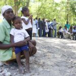 A mother waits with her child to enroll in the Surgical Accompaniment program.